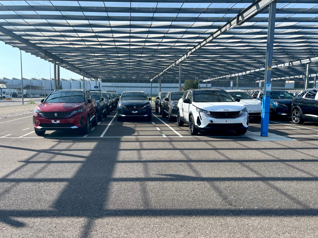 A scalable commercial fleet of modern mid size crossover SUVs parked organized under a structure for an independent car rental company fleet launch